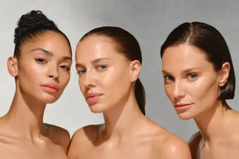 Drei Frauen mit strahlender Haut, die auf die Vorteile von onkologischer Kosmetik hinweisen.