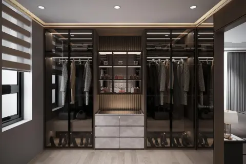 Elegancka garderoba z przeszklonymi szafami, wyeksponowanymi ubraniami i butami. Perfumy na półkach podkreślają styl moda quiet luxury.