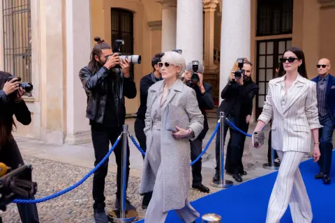 Il cast de "Il diavolo veste Prada" sfila sul red carpet, circondato da paparazzi. Meryl Streep e Anne Hathaway, icone di stile, catturano l'attenzione.