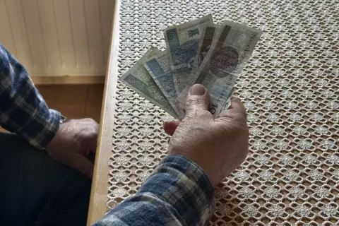 Dłoń trzyma banknoty. Czy to zapowiedź wyższego wskaźnika waloryzacji emerytur 2026?