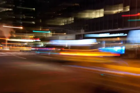 Des traînées lumineuses de voitures et de bâtiments dans des photos floues nocturnes.