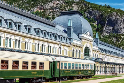 Estación de Canfranc, un lugar ideal donde comer bien en Jaca. Trenes clásicos esperan ante el imponente edificio.