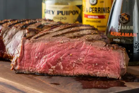 Saftiges Steak, perfekt gegrillt. Die Zutaten für **grillfleisch selber marinieren** liegen bereit: Senf, Worcestershire-Sauce und Sojasauce.