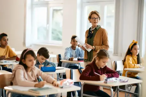 Lehrerin erklärt im Unterricht, während Schüler in Deutschland konzentriert arbeiten. Die Schulnoten sind ein wichtiger Teil des Bildungssystems.