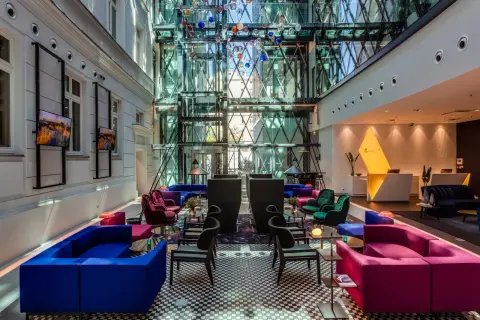 Nowoczesne wnętrze z kolorowymi sofami i szklaną fasadą, idealne na spotkanie w modnych restauracjach w Warszawie.