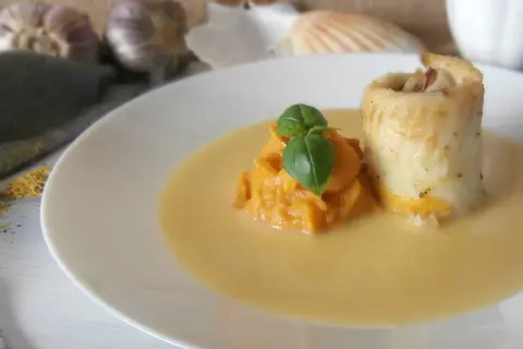 Roladka rybna z puree z dyni, udekorowana bazylią, podana w kremowym sosie beurre blanc.