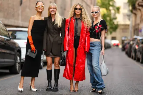Vier Frauen präsentieren unterschiedliche **dresscodes Frauen**: von elegantem Schwarz über lässige Jeans bis hin zu auffälligem Rot.