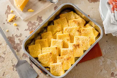 Gebackene Gnocchi alla Romana, goldbraun und mit Parmesan bestreut, bereit zum Servieren. Ein köstliches Rezept für jeden Anlass.