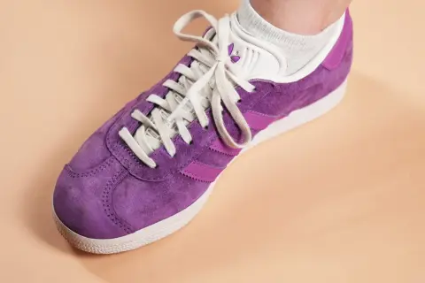 Une chaussure Adidas Gazelle violette, prête à nettoyer pour retrouver son éclat.