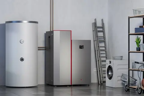Nowoczesna pompa ciepła obok bojlera i pralki. Wybór między pompą ciepła czy piecem elektrycznym to kluczowa decyzja dla domu.