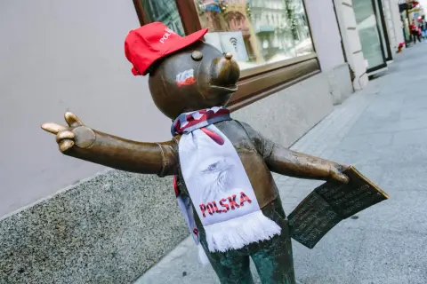 Pomnik misia z szalikiem "Polska" i czerwoną czapką, część szlaku łodzi bajkowej, pozdrawia przechodniów.
