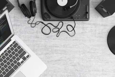 Laptop z programem do edycji dźwięku, gramofon, słuchawki i płyty winylowe. Tworzenie muzyki, sample co to?