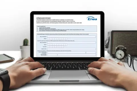 Laptop z otwartym formularzem "Oświadczenie" i rękami użytkownika wpisującymi dane.