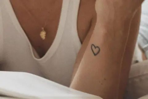Un corazón tatuado en la muñeca, un detalle sutil para quienes buscan los mejores sitios para hacerse un tatuaje.