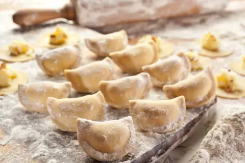 Gotowe do lepienia pierogi, posypane mąką. Zastanawiasz się, jaka mąka na pierogi będzie najlepsza? Ta wygląda idealnie!