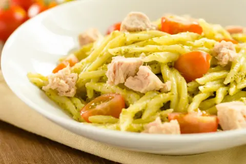 Pasta fredda al pesto con tonno e pomodorini, un piatto estivo fresco e saporito.