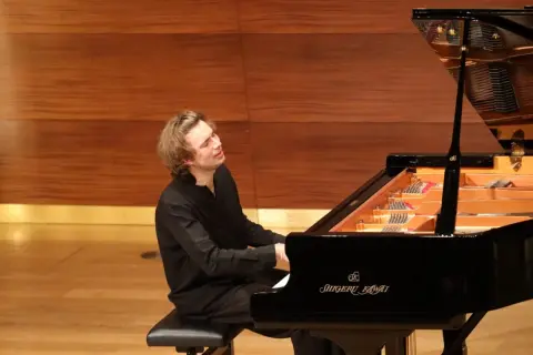 Ein junger Mann spielt mit Leidenschaft Klavier. Seine Hingabe lässt ihn wie den besten Pianisten der Welt wirken.