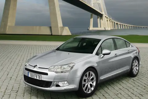 Srebrny Citroen C5 na tle mostu. Wiele osób chwali ten model, a opinie o Citroen C5 są zazwyczaj pozytywne.