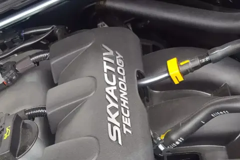 Silnik SKYACTIV TECHNOLOGY, jeden z najlepszych silników benzynowych, z widocznymi przewodami i złączkami.