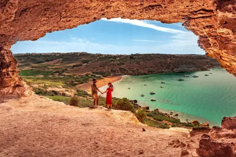 Para zakochanych podziwia widok na zatokę z łodziami. Malta pogoda wrzesień idealna na wakacje.