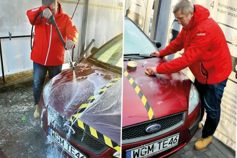 Mężczyzna myje i woskuje samochód na myjni bezdotykowej. Najpierw spłukuje auto pianą, a potem nakłada wosk.
