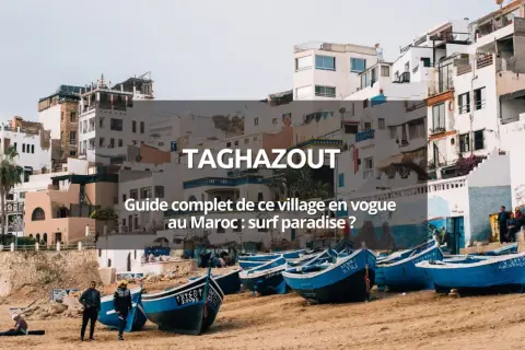 Village de pêcheurs à Taghazout, Maroc. Bateaux bleus sur la plage, maisons blanches perchées. Un paradis pour le surf au Maroc.