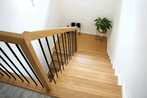 Nowe schody drewniane z czarnymi balustradami. Zobacz, jak zrobić schody drewniane, by nadać domowi ciepły i nowoczesny wygląd.