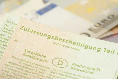 Zulassungsbescheinigung Teil I. Wichtig für auto abmelden nach verkauf ohne brief. Euroscheine im Hintergrund.