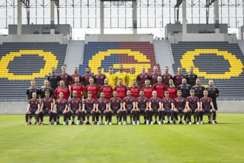 Drużyna Pogoń Szczecin dzisiaj pozuje do zdjęcia na tle stadionu.