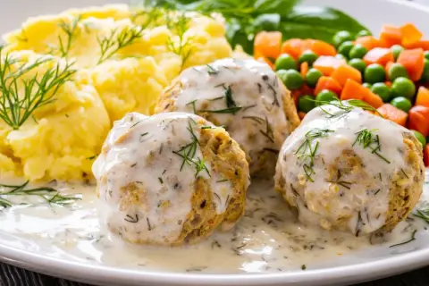 Pyszne pulpeciki w kremowym sosie, podane z puree ziemniaczanym i warzywami. Idealny pomysł, jak zrobić sos do pulpetów, by danie było wyborne!