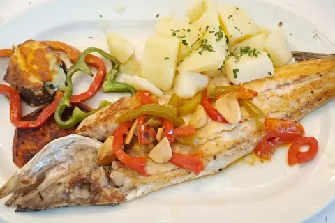 Lubina a la bilbaina con patatas y pimientos asados. Un plato delicioso y saludable.