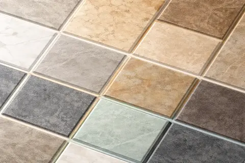 Szeroki wybór płytek ceramicznych w różnych odcieniach i wzorach, z widoczną fugą z trasem.
