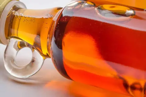 Nahaufnahme einer Flasche mit goldenem ahornsirup baby.