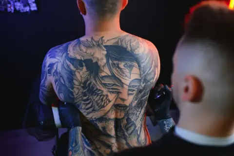 Męski tatuaż na barku z wieloma oczami i demoniczny motyw.