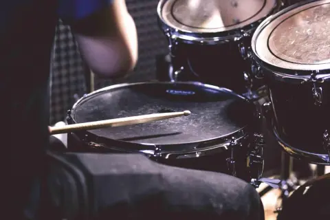 Pałeczka spoczywa na werblu, gotowa do uderzenia w ten duży instrument perkusyjny.