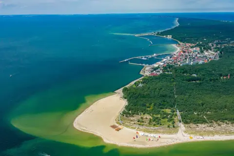 Widok z lotu ptaka na Hel – polskie egzotyczne miejsca z piaszczystą plażą, lasem i portem.