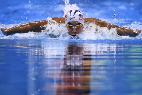 Swimmer Michael Phelps demonstrates how to swim butterfly stroke, powering through the water with a powerful dolphin kick and arm pull.