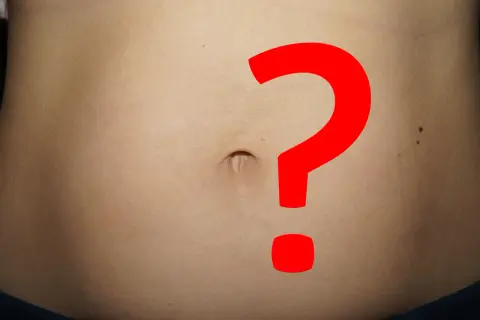 Brzuch z dużym czerwonym znakiem zapytania. Obfity okres, a jednak ciąża? Niepewność i pytania.