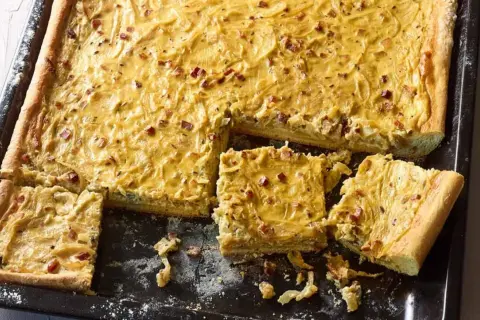 Herzhafter Zwiebelkuchen mit Speck, perfekt für ein gemütliches Abendessen. Hier ist ein einfaches Zwiebelkuchen Rezept.