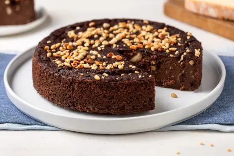 Torta di pane al cioccolato, soffice e ricca, guarnita con pinoli tostati. Un dolce goloso che profuma di casa.