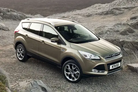 Złoty Ford Kuga na kamienistym podłożu. Poznaj jego wymiary i możliwości terenowe.