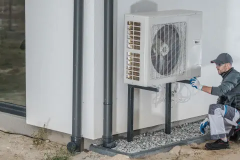 Un technicien vérifie une pompe à chaleur extérieure, étape clé pour le calcul rentabilité pompe à chaleur.