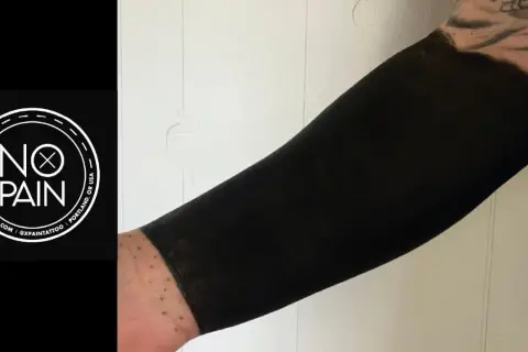 Brazo cubierto con un tatuaje de blackout, un estilo que transforma la piel en una superficie negra intensa.