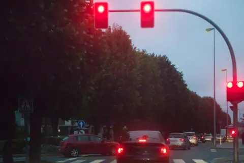 Voitures arrêtées à un feu rouge. La verbalisation camera feu rouge est imminente si le feu passe au vert.