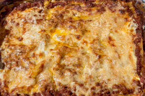 En gyllene, bubblande lasagne som precis kommit ur ugnen. Perfekt lasagne tid i ugn!