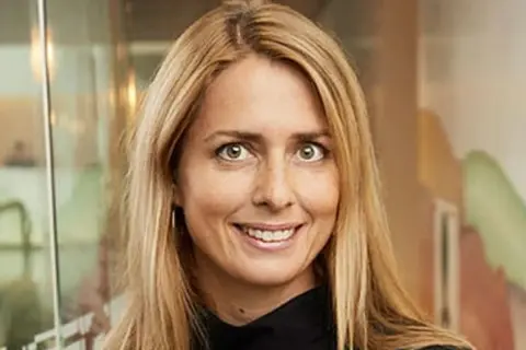 Helena Helmersson, VD för H&M, ler mot kameran. Hon har blont hår och bär en svart tröja.