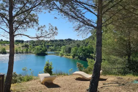 Deux chaises longues en pierre invitent à la contemplation du lac du Crès. L'itinéraire de ce lieu paisible est un appel à la nature.
