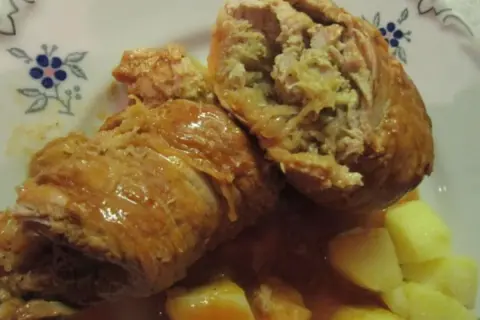 Zwei saftige Rouladen, gefüllt mit einer herzhaften Mischung, serviert mit Kartoffeln und einer köstlichen Sauce. Ein klassisches Gericht, das an ein deftiges Schnitzel mit Sauerkraut erinnert.