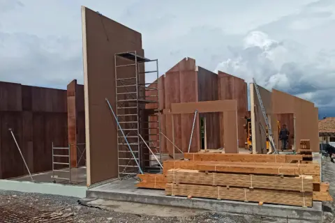Construcción de casas entramado ligero con paneles prefabricados de madera. Andamios y materiales listos para seguir levantando las estructuras.