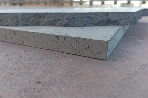 Due piastrelle in pietra lavica, una più chiara e porosa, l'altra più scura e compatta, mostrano la loro texture unica.